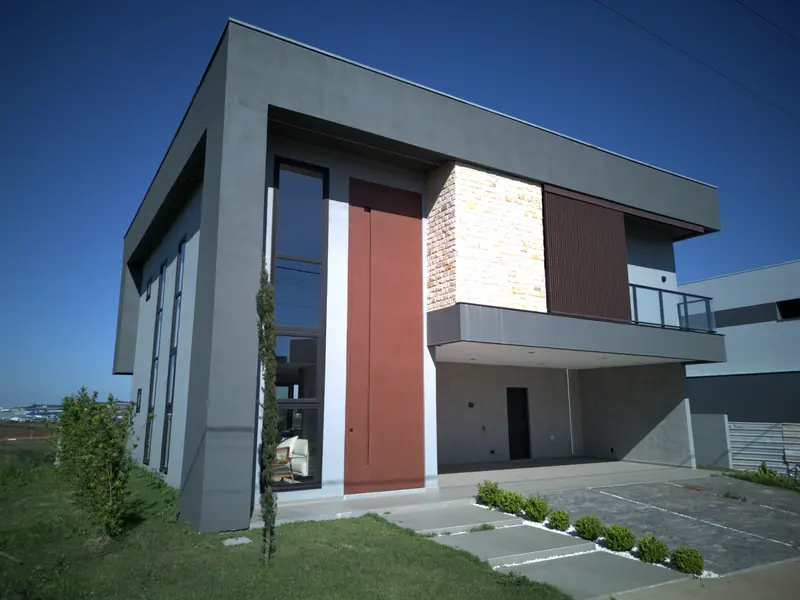 Fachada da Casa Malbec vista de drone, com a porta de 6 metros, pedra e esquadrias pretas